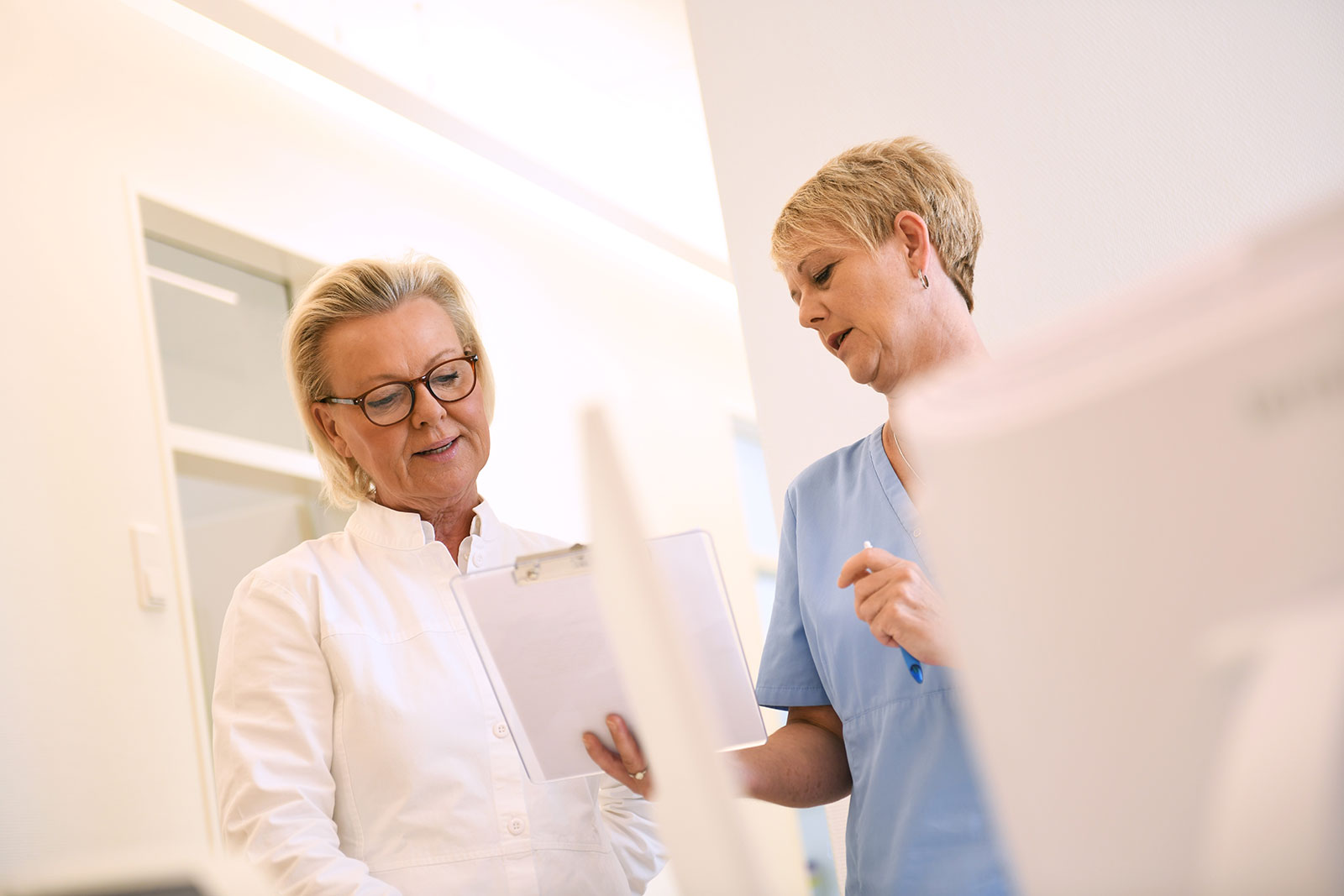 Dr. Nicola Friesen stimmt sich mit Mitarbeiterin über die Behandlung ab