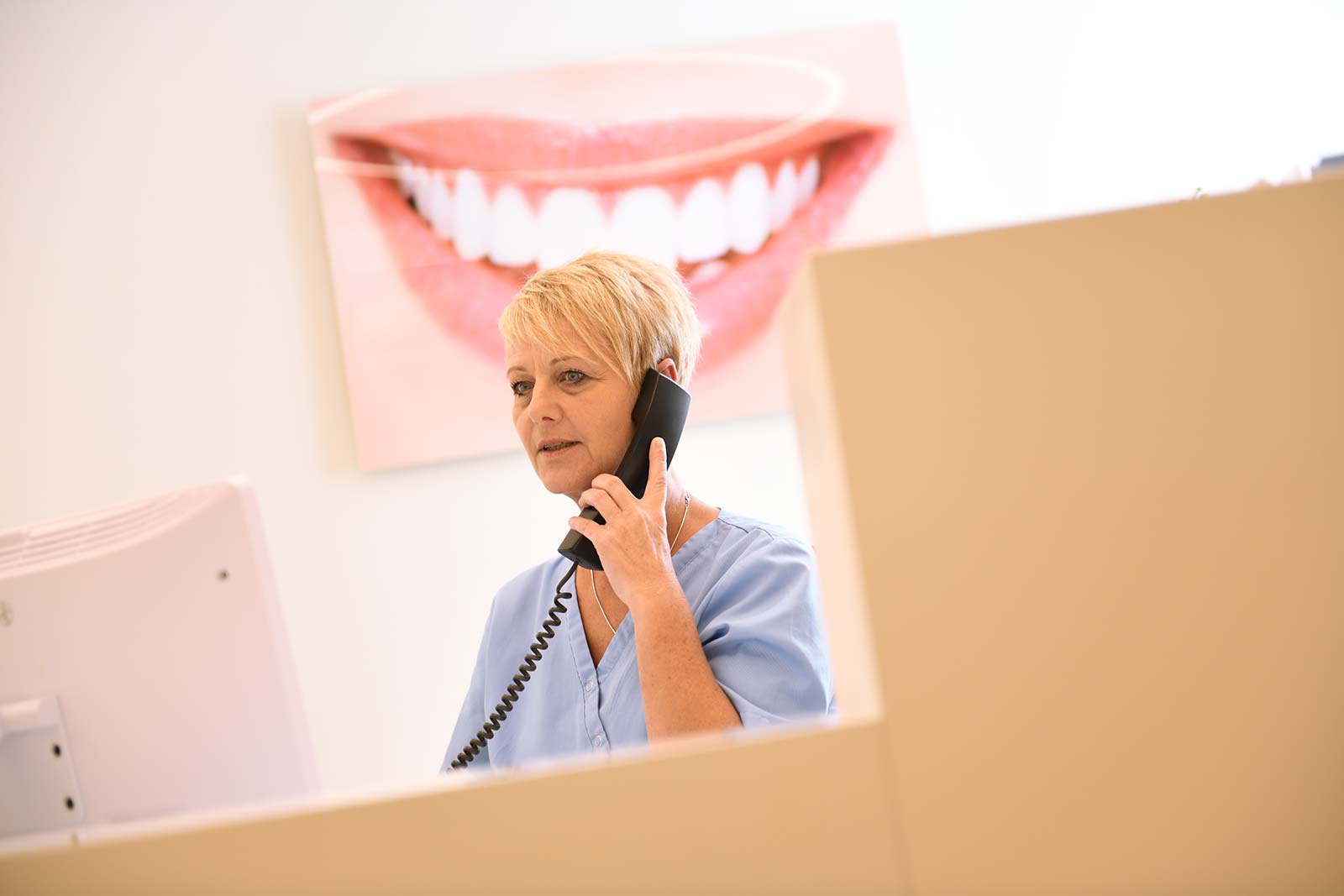 Mitarbeiterin telefoniert mit Patienten