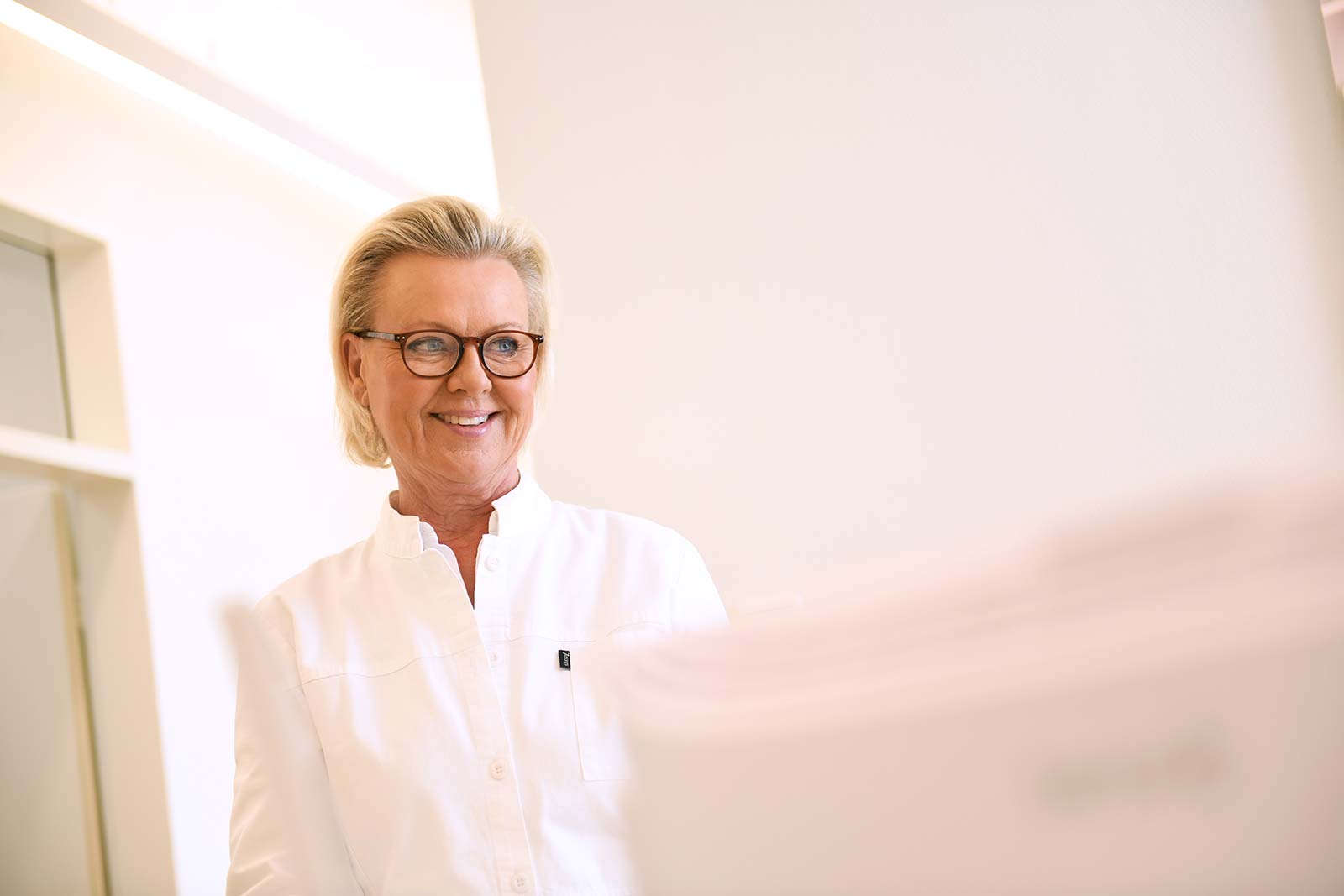 Dr. Nicola Friesen erklärt Ihrer Mitarbeiterin etwas – Die Mitarbeiterin lächelt freundlich